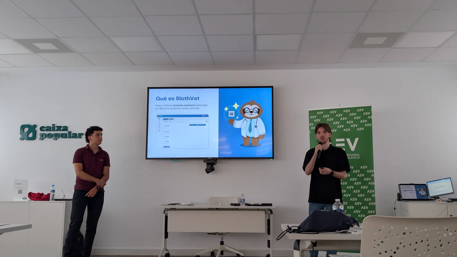 Jorge presenting SlothVet with a microphone next to a screen showing the product, at an AEVETVAL session in Valencia